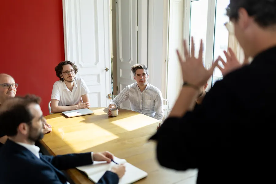 Un atelier autour d’une table : une équipe écoute une présentation